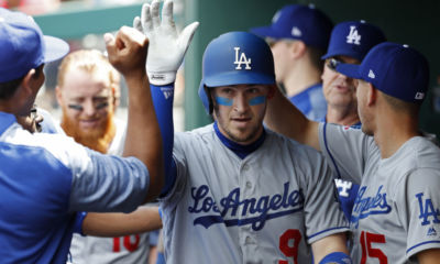 May 20, 2018; Washington, DC, USA; Los Angeles Dodgers catcher Yasmani Grandal (9) celebrates with teammates in the dugout after hitting a solo home run against the Washington Nationals in the first inning at Nationals Park. Mandatory Credit: Geoff Burke-USA TODAY Sports